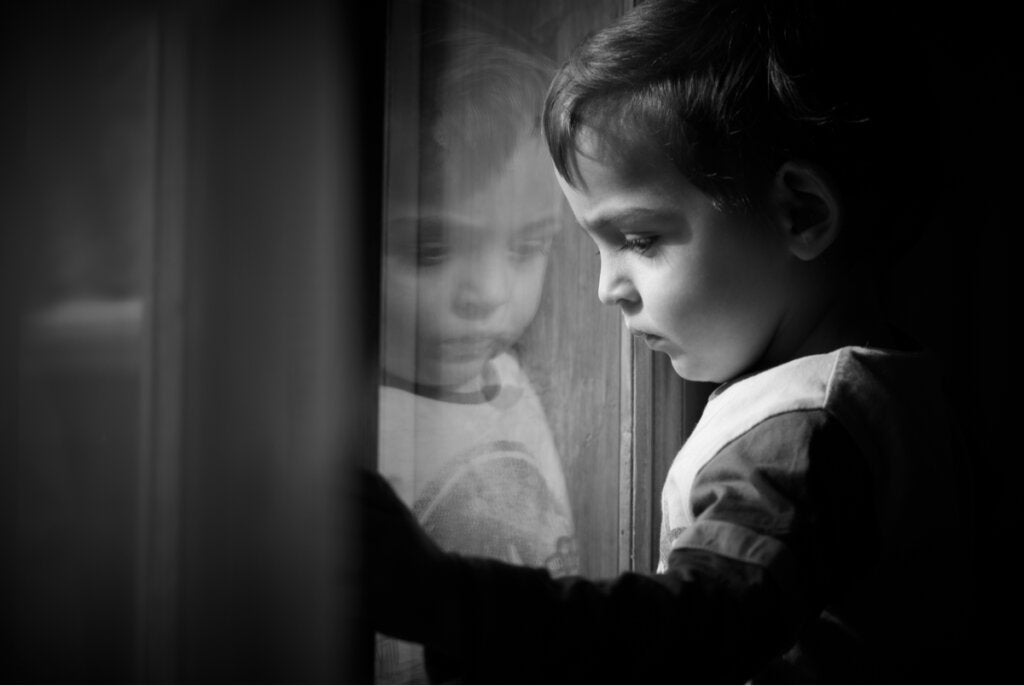 Çocukluk travmasının beyin taramalarında nasıl ortaya çıktığını göstermek için pencereden dışarı bakan üzgün çocuk