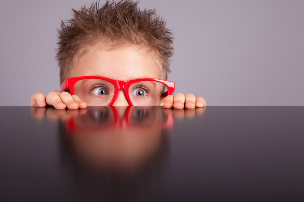 Çocukların yetişkinlerin görmediği uyaranları algıladıklarını simgeleyen kırmızı gözlüklü meraklı çocuk