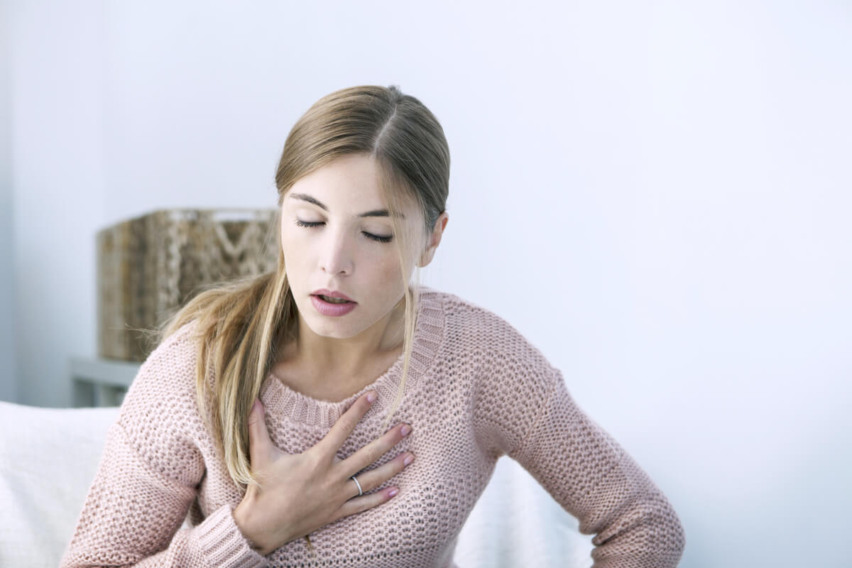 Mujer haciendo un corazón con sus manos representando Por qué cuando estamos tristes nos duele el pecho