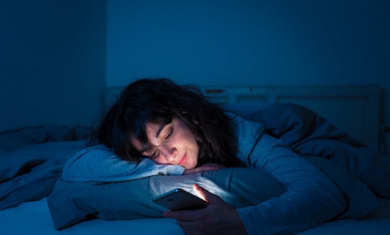 Mujer pensando en apagar el móvil antes de ir a dormir
