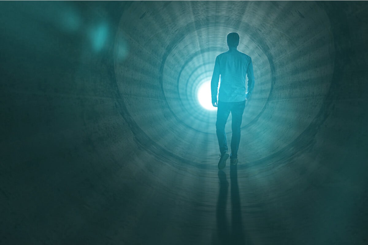 Hombre andando hacia una puerta con luz