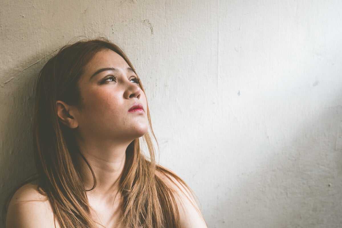 Mujer en la cama triste por herida de la humillación