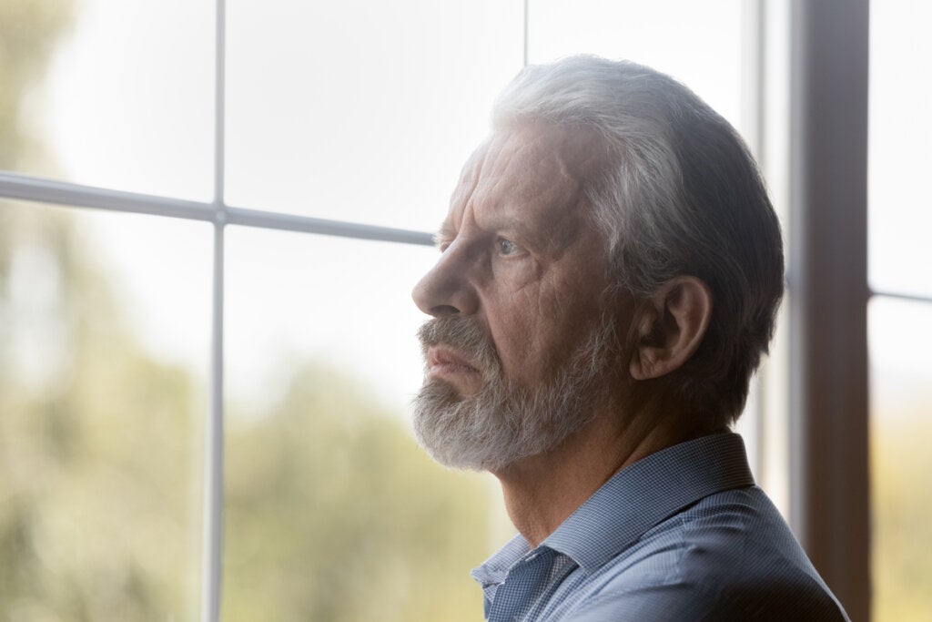 50 yaşından sonra yalnız yaşamayı düşünen pencereden dışarı bakan adam