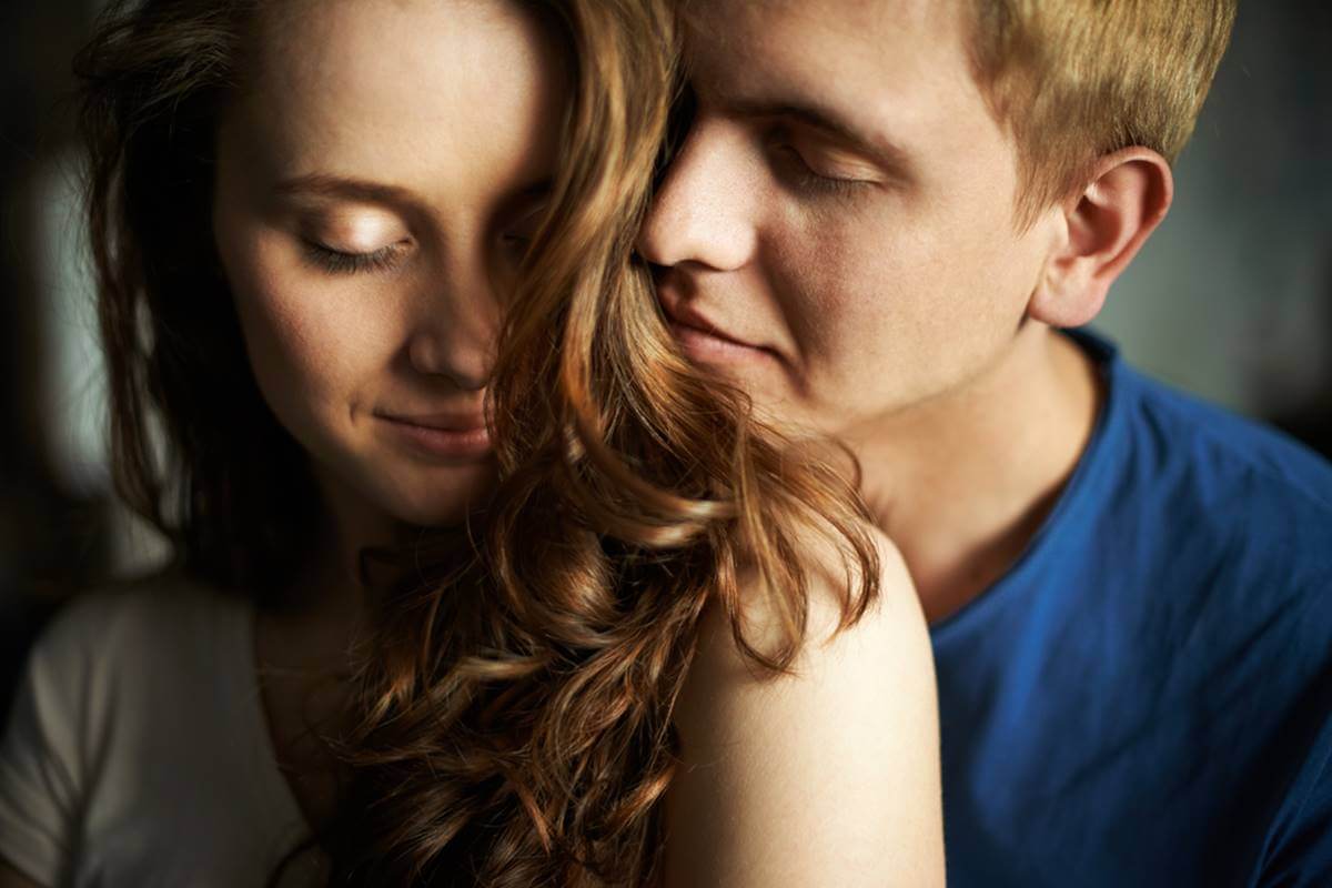 Pareja besándose en la cama