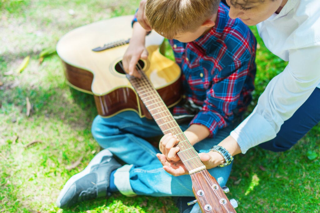 Gitar çalmayı öğrenen çocuk